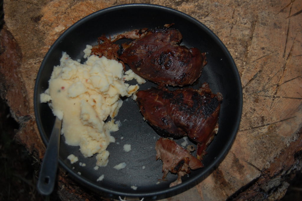 Grouse cooked on cast-iron over a campfire, with mashed potatoes